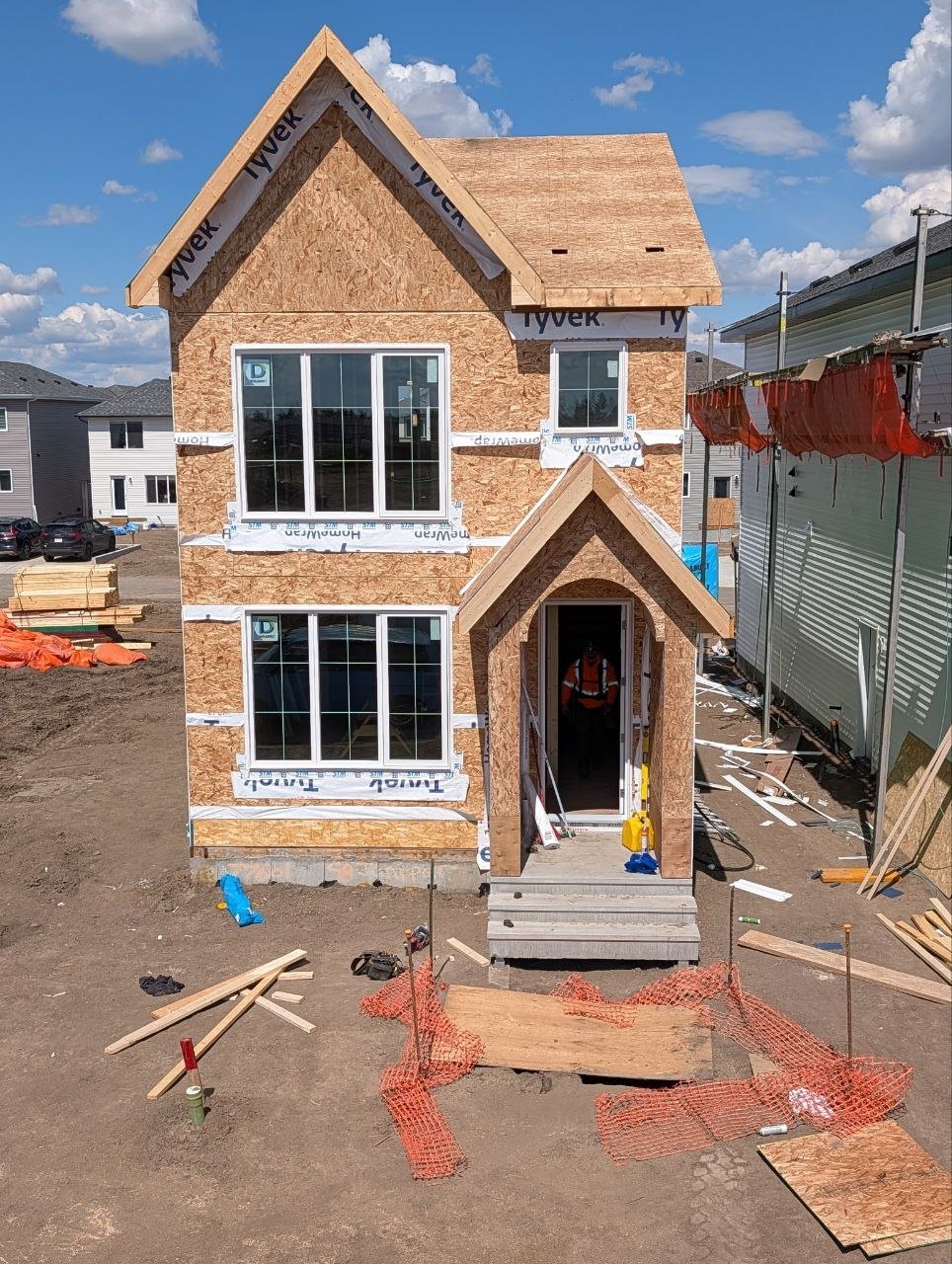 Framed two-storey house with installed windows and a gable entry